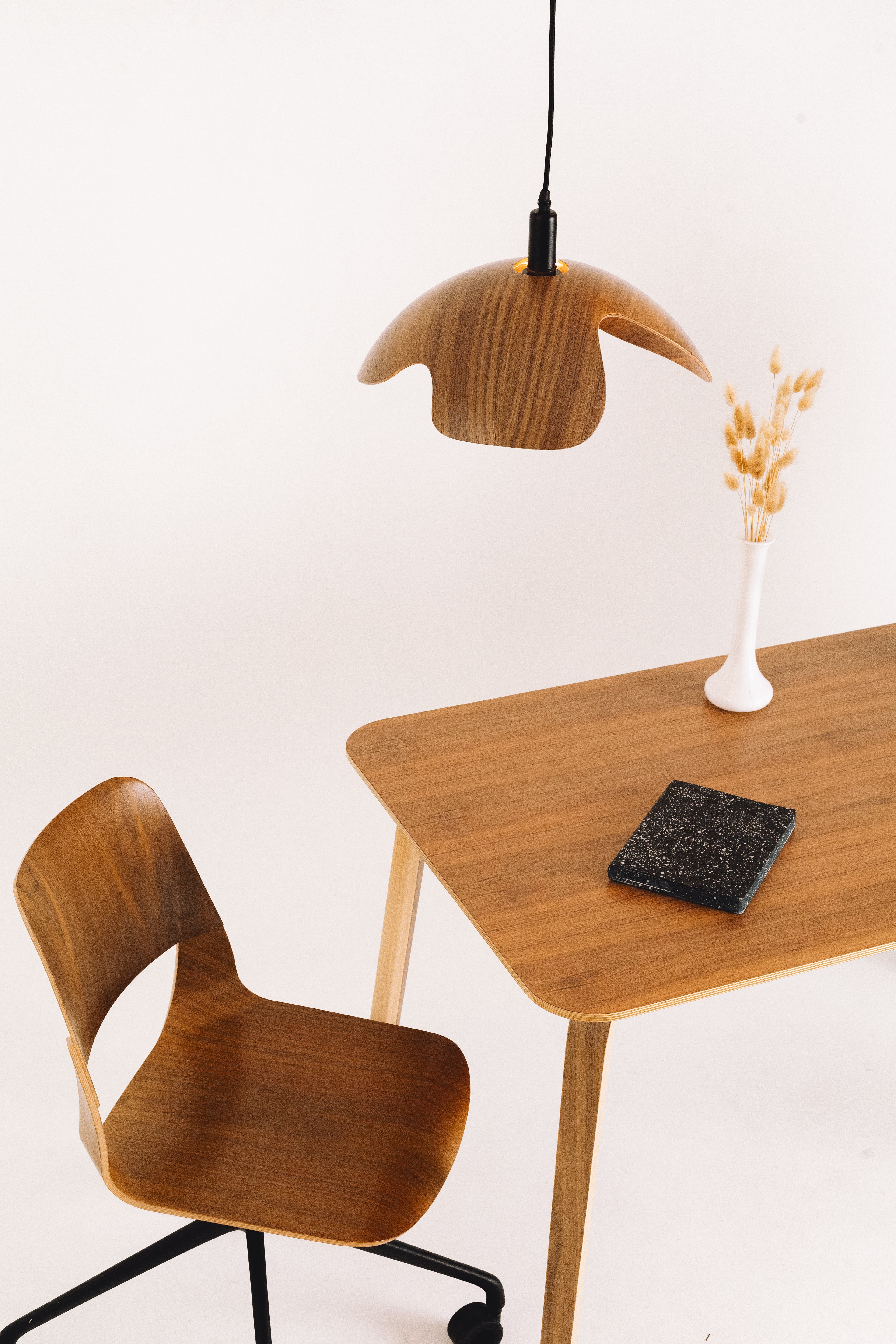Wooden chair and table with a pendant lamp on a white background