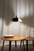 Modern wooden pendant light over a wooden table with minimalist decor.