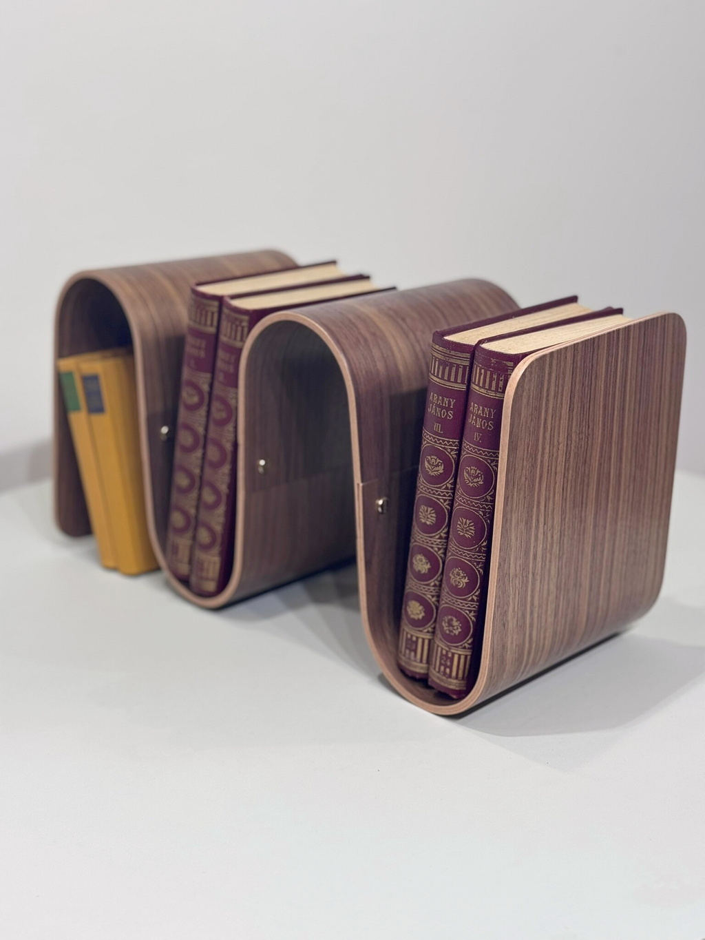 Wooden bookends with books on a white background