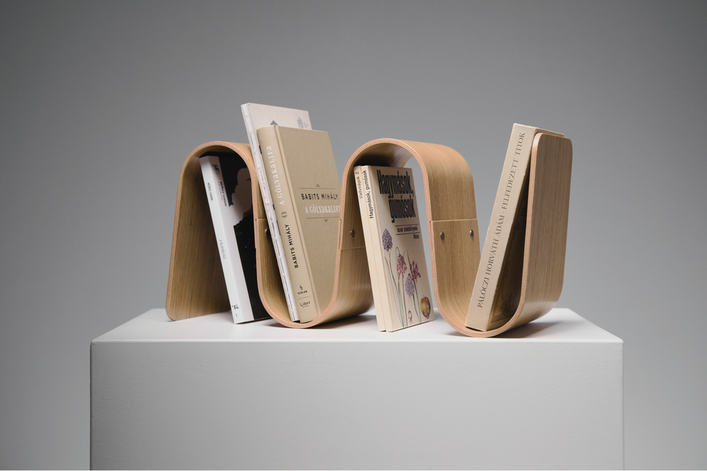 Bookend shaped like a wave holding books on a gray background