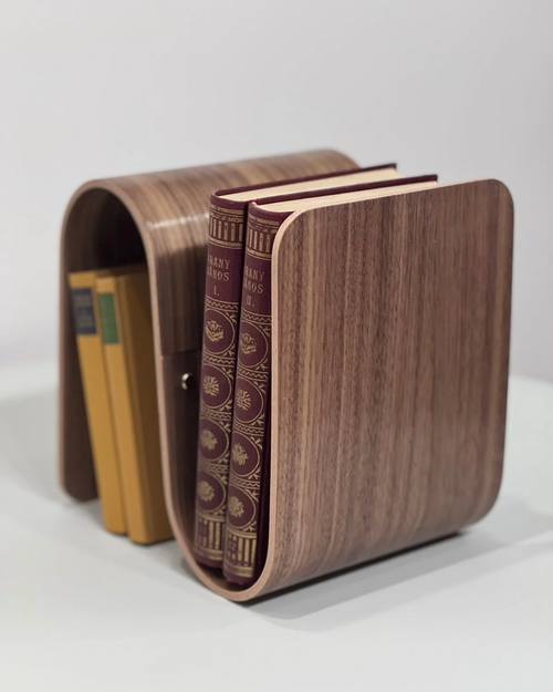 Wooden bookend holding books on a white background