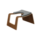 Modern yoga headstand stool with wooden base and grey cushion on a white background